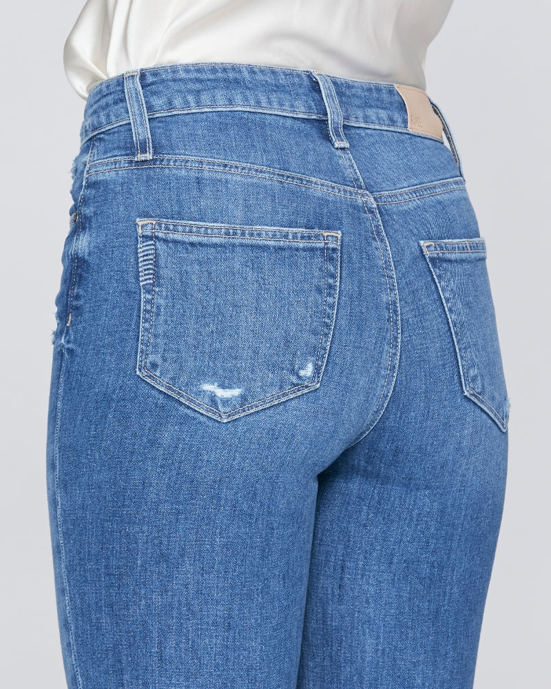 The back view of a woman in Paige's Sarah Straight Crop - Love Letter Distressed blue jeans.