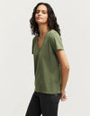 person wears the denham khaki ramona v-neck tee against a grey studio background showing the side of the Tee. 