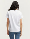 person wears the denham white ramona v-neck tee against a grey studio background showing the back of the Tee. 