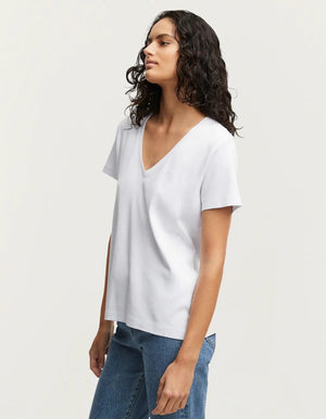 person wears the denham white ramona v-neck tee against a grey studio background showing the side of the Tee. 