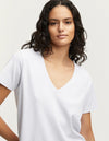 person wears the denham white ramona v-neck tee against a grey studio background showing the front of the Tee. 
